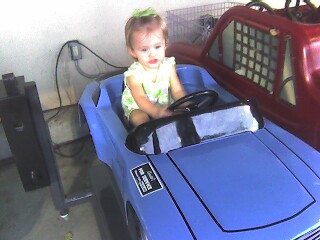 Ella rides the play car at HEB